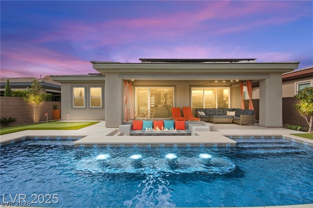 103 Reflection Cove Drive Henderson, NV 89011 - Photo 2 of 66 Back of property at dusk with a fenced backyard, an outdoor pool, stucco siding, and a patio