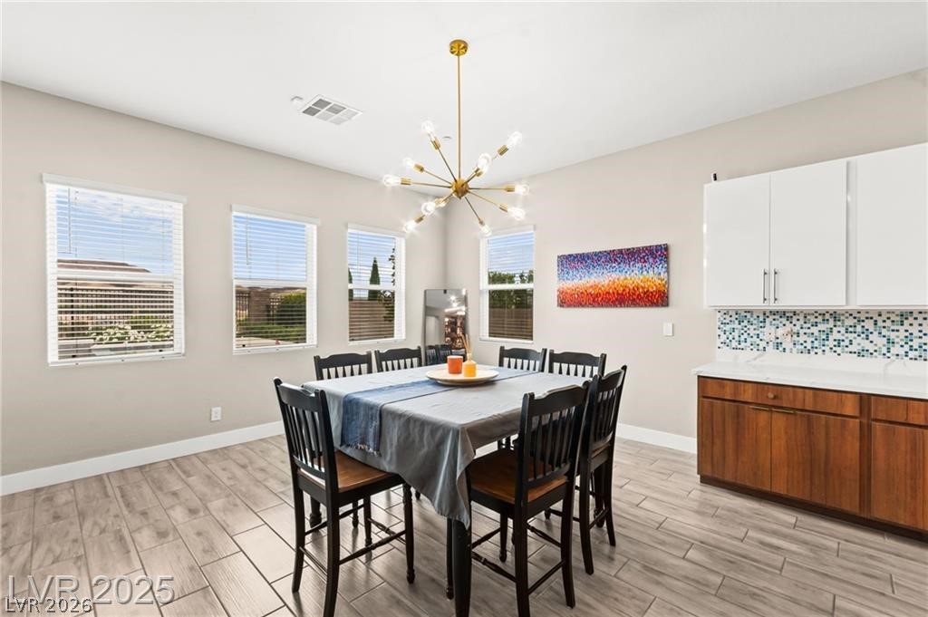 103 Reflection Cove Drive Henderson, NV 89011 - Photo 21 of 66 Dining room with a chandelier and light wood-style flooring
