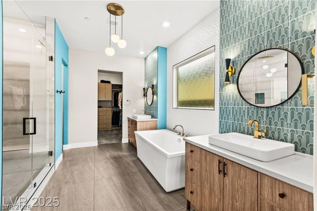 103 Reflection Cove Drive Henderson, NV 89011 - Photo 29 of 66 Full bath with a stall shower, a soaking tub, two vanities, a walk in closet, and recessed lighting