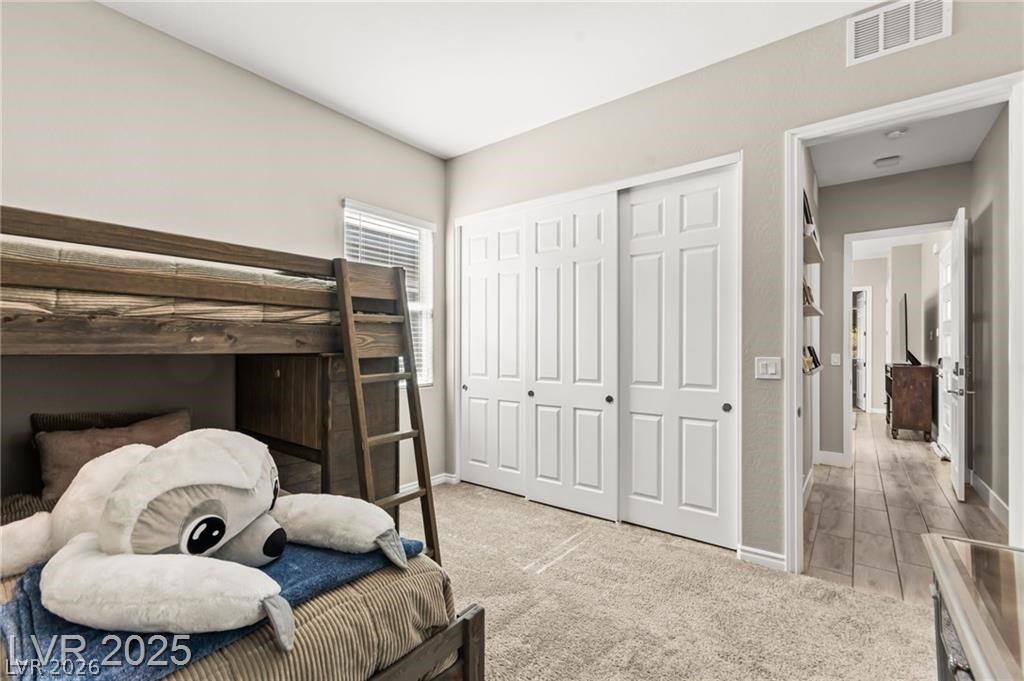 103 Reflection Cove Drive Henderson, NV 89011 - Photo 51 of 66 Bedroom with light colored carpet and a closet