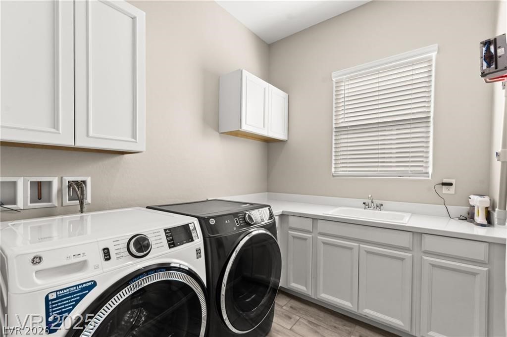 103 Reflection Cove Drive Henderson, NV 89011 - Photo 52 of 66 Laundry room featuring light wood-type flooring, washer and clothes dryer, and cabinet space