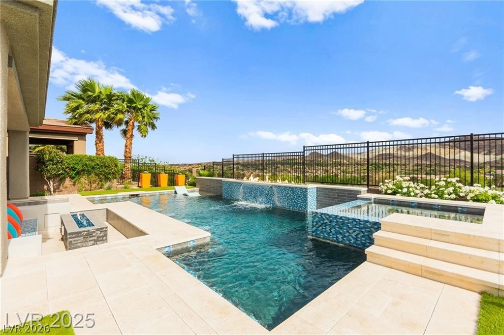 103 Reflection Cove Drive Henderson, NV 89011 - Photo 58 of 66 View of swimming pool featuring an in-ground hot tub, a patio area, a fenced backyard, and a fire pit