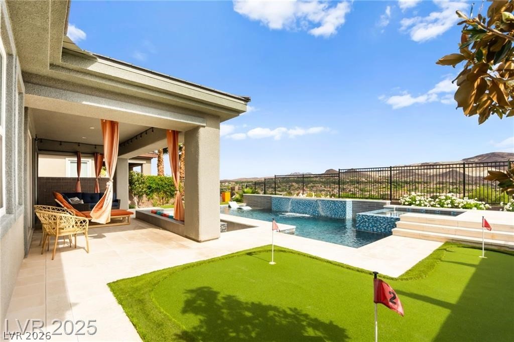 103 Reflection Cove Drive Henderson, NV 89011 - Photo 59 of 66 View of pool with a fenced backyard, a patio area, a putting green, and a pool with connected hot tub