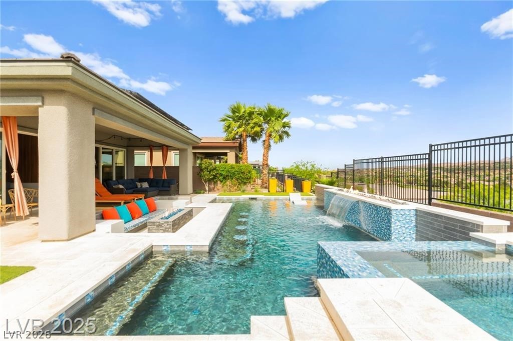 103 Reflection Cove Drive Henderson, NV 89011 - Photo 61 of 66 View of pool featuring a fenced backyard, a patio area, a pool with connected hot tub, and an outdoor living space with a fire pit