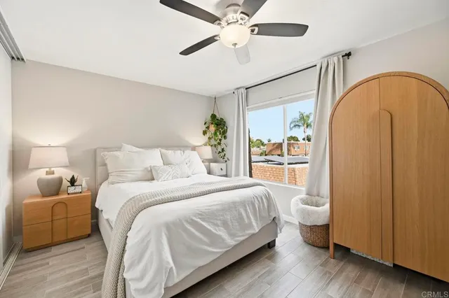 a bedroom with a bed wooden floor and window