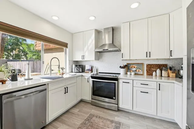 a kitchen with white cabinets stainless steel appliances and sink