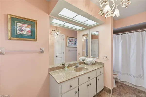 a bathroom with a granite countertop sink a mirror and a shower