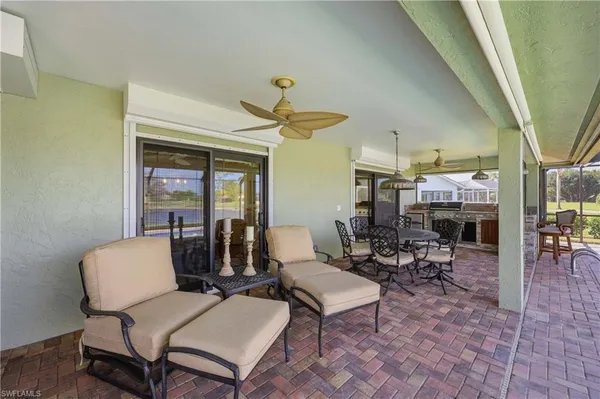 a living room with patio furniture and a chandelier