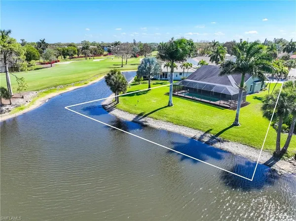 an aerial view of a house with a yard and lake view