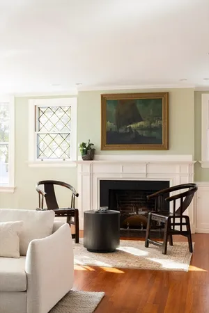 a living room with fireplace furniture and a large window