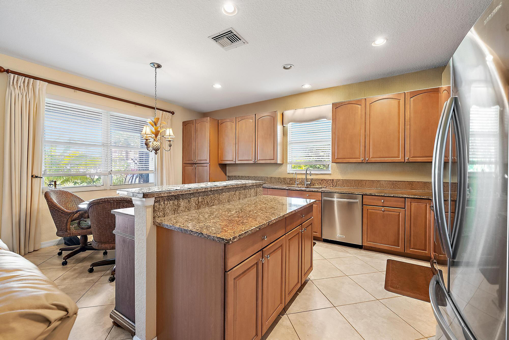 2912 Southwest Porpoise Circle Stuart, FL 34997 - Photo 11 of 36 a kitchen with kitchen island granite countertop a sink appliances and cabinets
