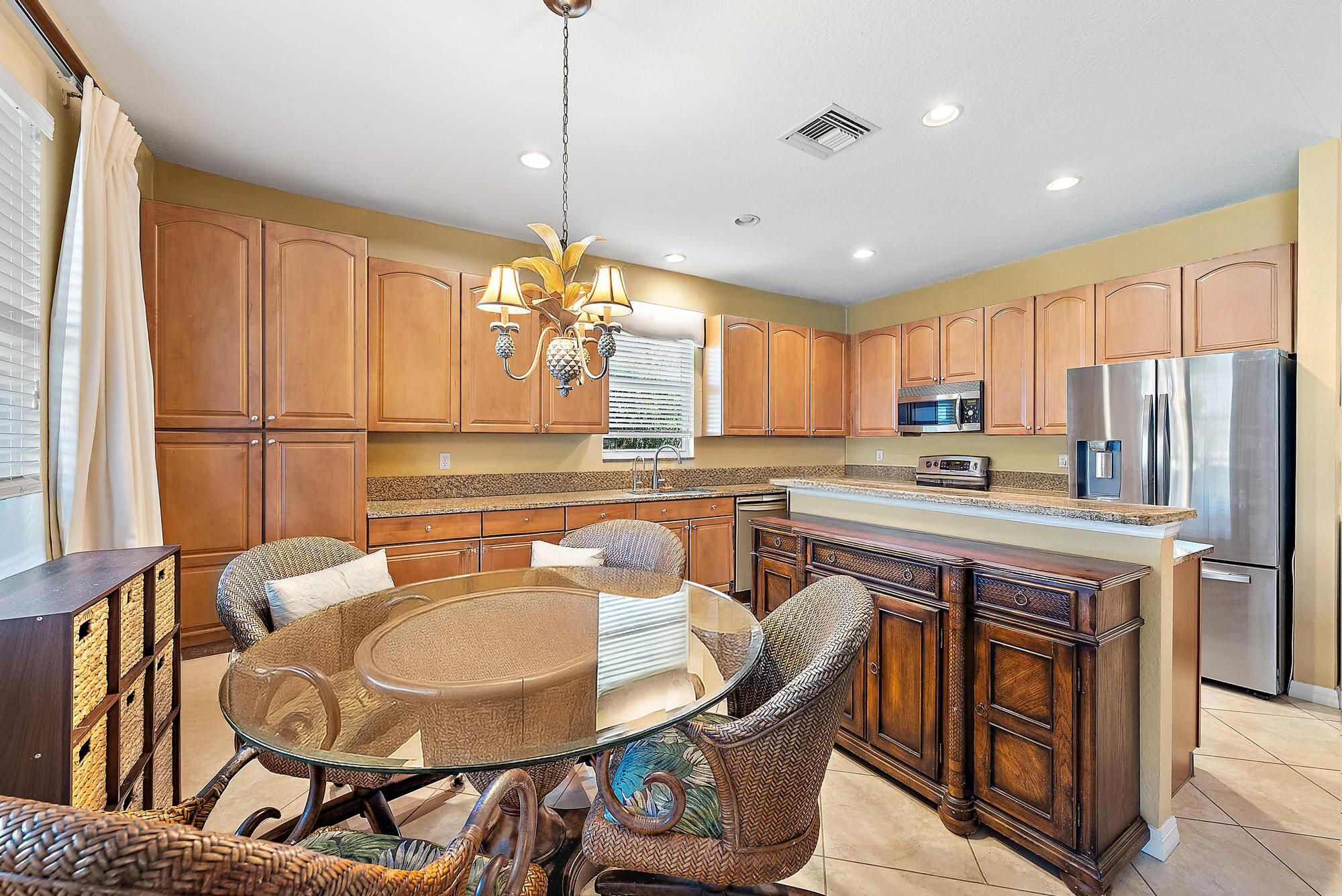 2912 Southwest Porpoise Circle Stuart, FL 34997 - Photo 12 of 36 a kitchen with stainless steel appliances granite countertop a stove a refrigerator a kitchen island a table and chairs