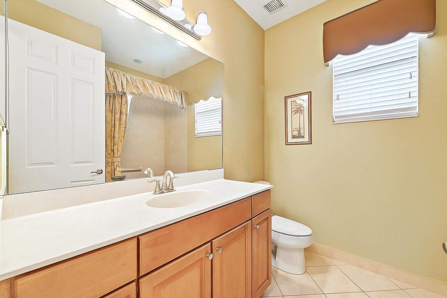 2912 Southwest Porpoise Circle Stuart, FL 34997 - Photo 18 of 36 a bathroom with a sink a toilet and mirror