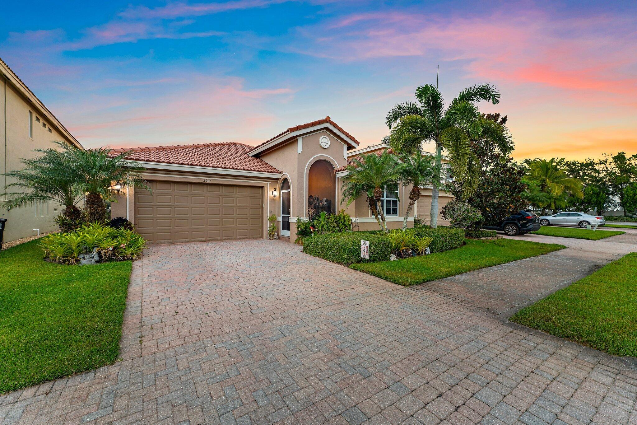 2912 Southwest Porpoise Circle Stuart, FL 34997 - Photo 2 of 36 a front view of a house with garden