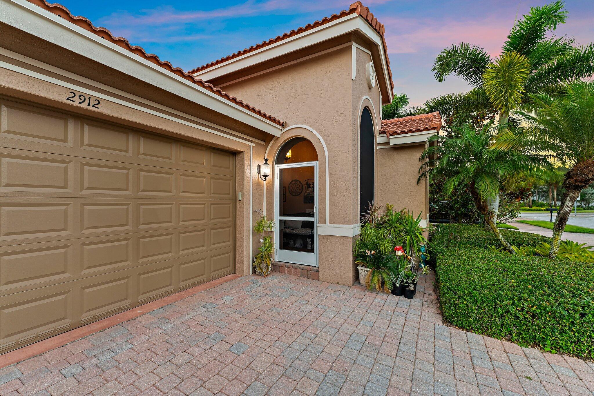 2912 Southwest Porpoise Circle Stuart, FL 34997 - Photo 3 of 36 a front view of a house with a garden