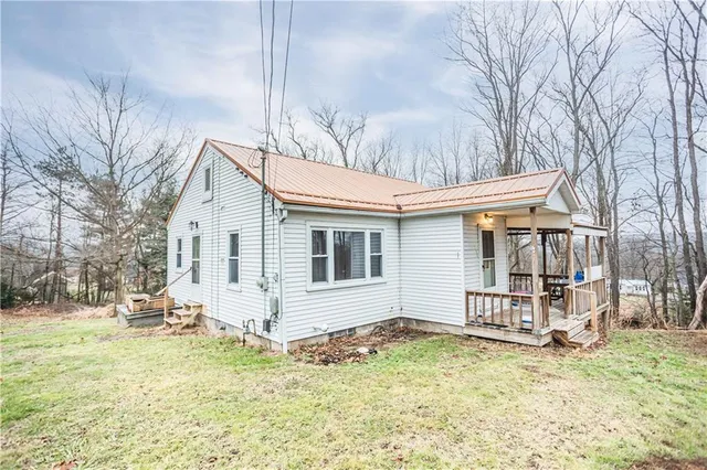 a view of a white house with a yard covered in snow
