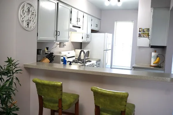a kitchen with a table and a clock on the wall