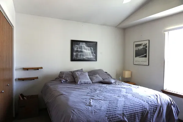 a bedroom with a bed and a painting on the wall