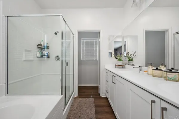 a bathroom with a double vanity sink and shower