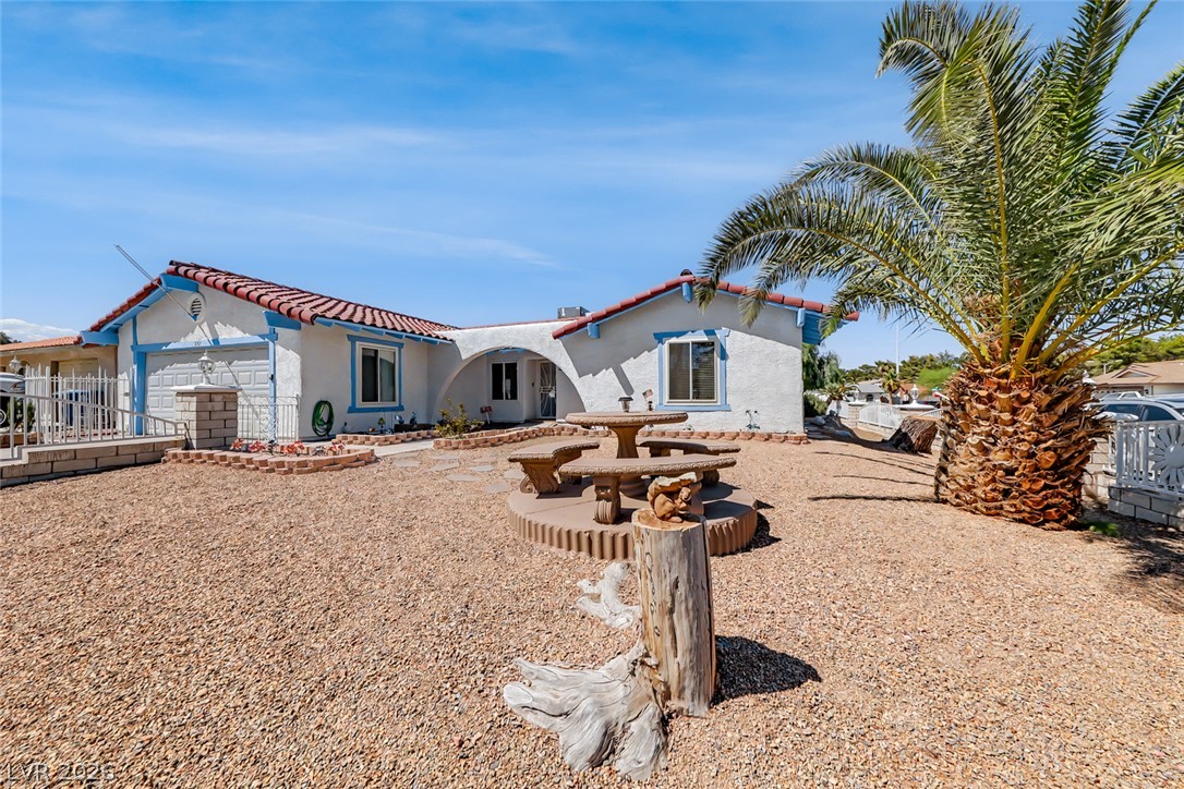 3107 Trueno Road Henderson, NV 89014 - Photo 6 of 37 A spacious home with desert landscaping and a mature palm, perfect for outdoor living.
