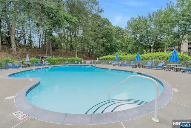 a view of a swimming pool with a yard and sitting area