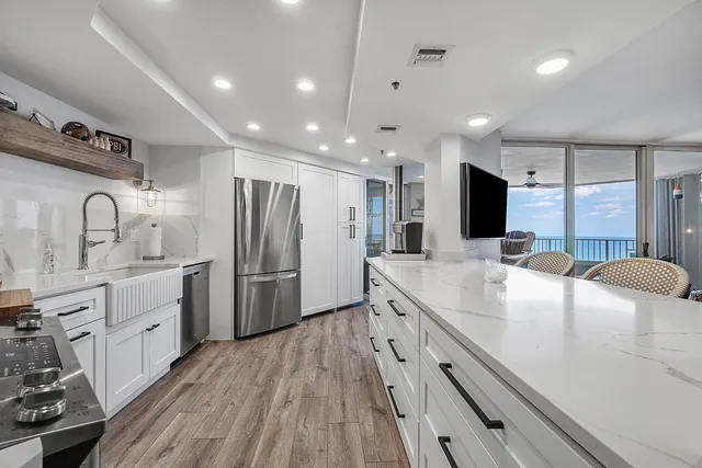 a large kitchen with kitchen island a sink stainless steel appliances and cabinets