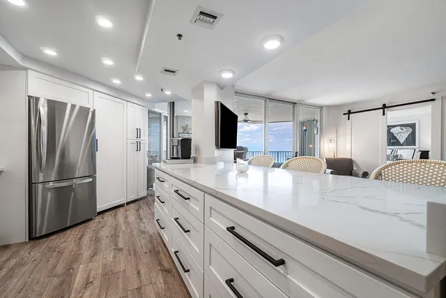 a kitchen with kitchen island a counter top space wooden floor and stainless steel appliances