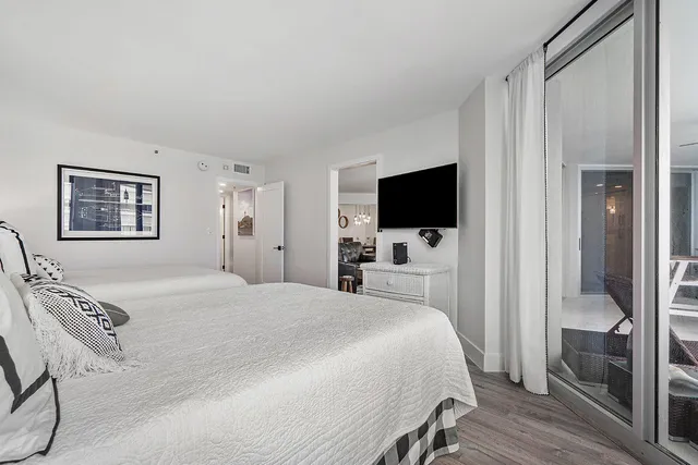 a bedroom with a bed and a flat tv screen on wall