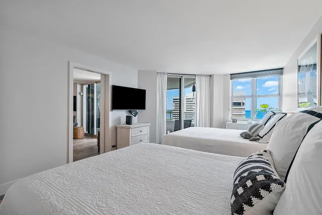 a bedroom with a bed and a flat tv screen on dresser