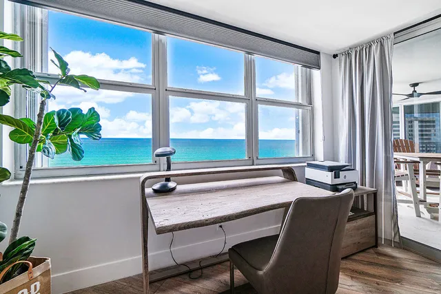 a view of a workspace with furniture and a window