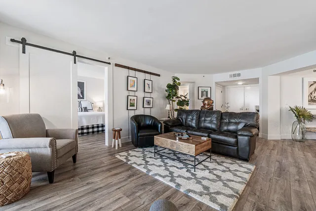 a living room with furniture and a wooden floor