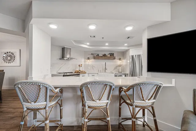 a kitchen with a dining table chairs and refrigerator