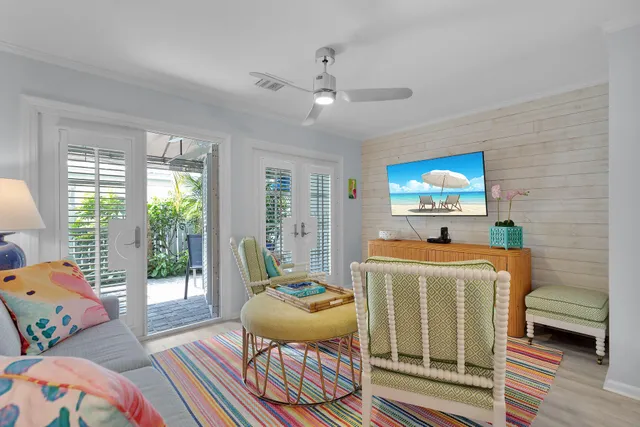 a living room with a baby crib furniture and a flat screen tv
