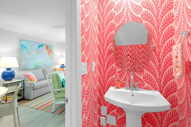 a bedroom with a bed painting on wall and a potted plant