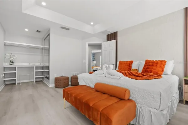 a bed sitting in a bedroom and a chandelier