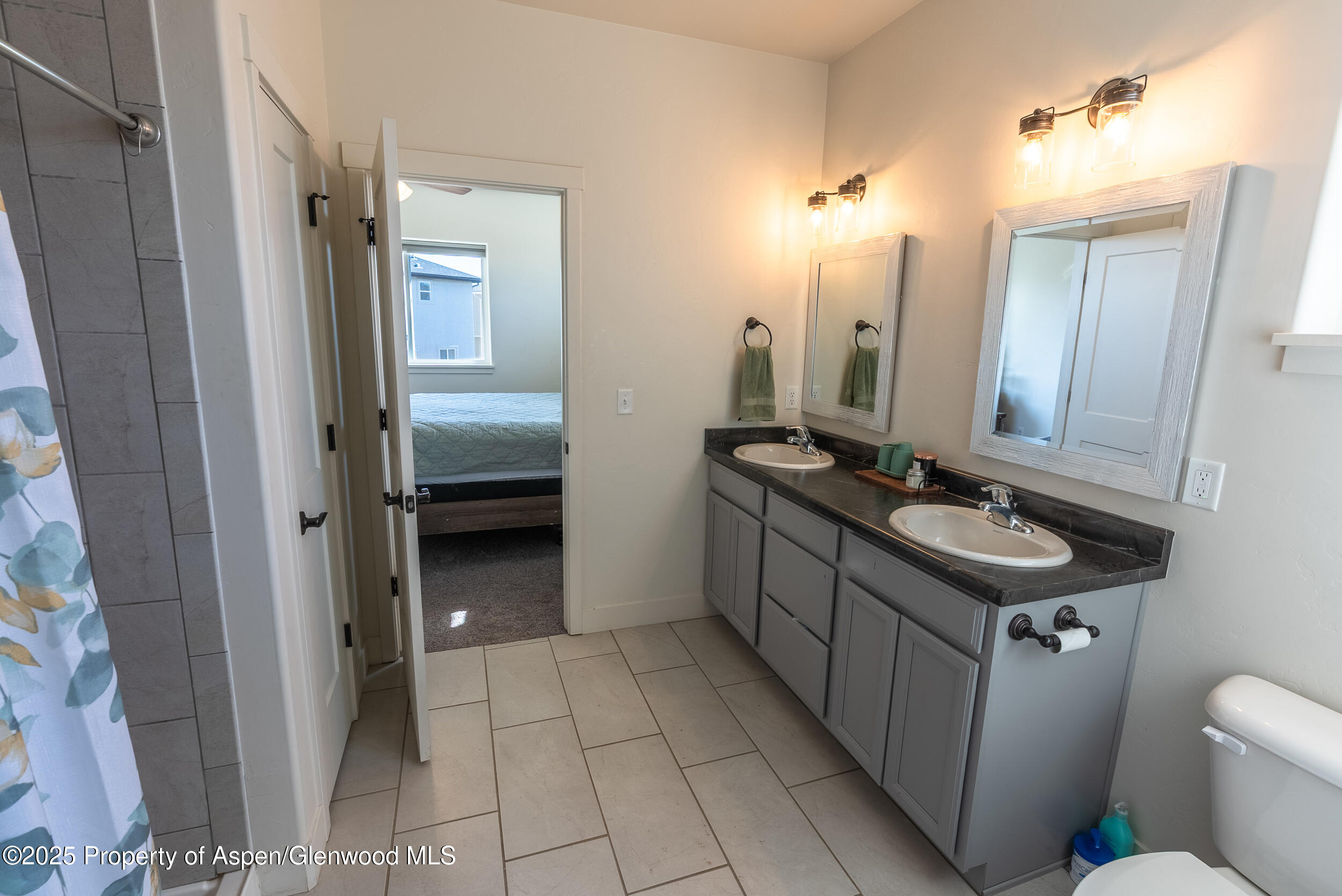 1149 East 17th Street Rifle, CO 81650 - Photo 9 of 16 a bathroom with a sink a toilet and mirror