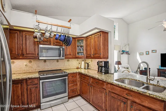 a kitchen with refrigerator and chairs
