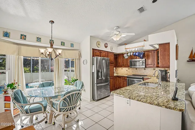 a kitchen with stainless steel appliances granite countertop a sink a stove and a wooden floors