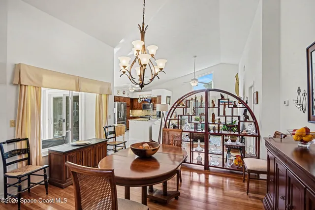 a living room with furniture a chandelier and a bookshelf