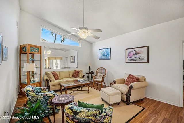 a living room with furniture kitchen view and a chandelier