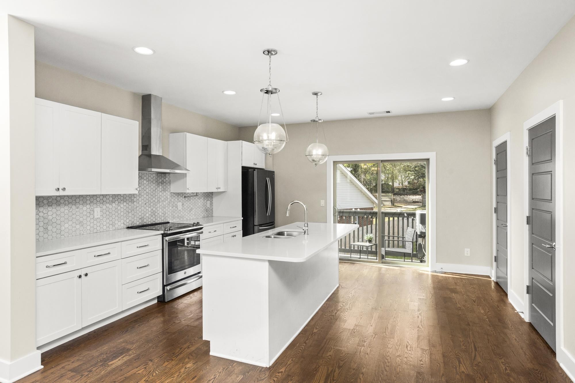 a large kitchen with stainless steel appliances a lot of counter space and a wooden floor