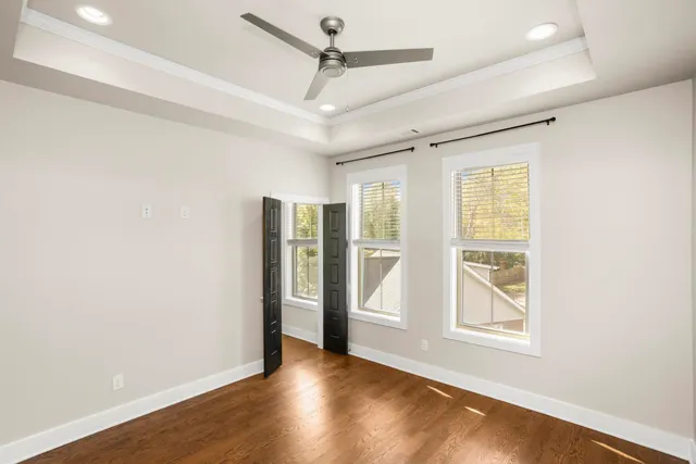 a view of an empty room with a window and wooden floor