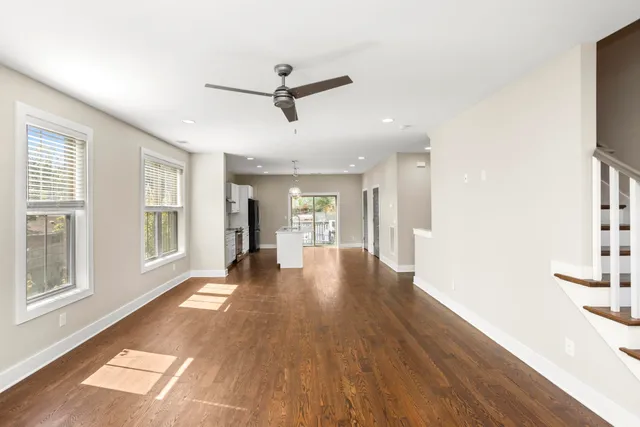 a view of a big room with wooden floor and windows