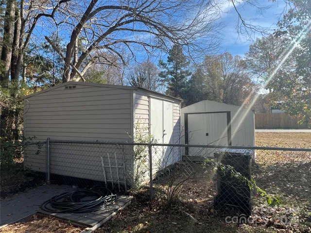a view of a house with backyard and wooden fence