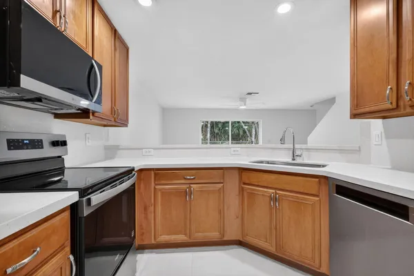 a kitchen with stainless steel appliances granite countertop a refrigerator a sink a stove and island