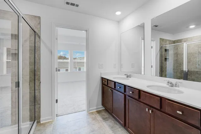 a bathroom with a shower sink and mirror