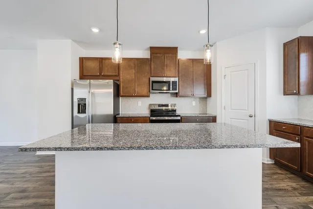 a kitchen with stainless steel appliances granite countertop a sink refrigerator and microwave