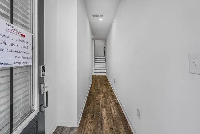 a view of a hallway with wooden floor and staircase