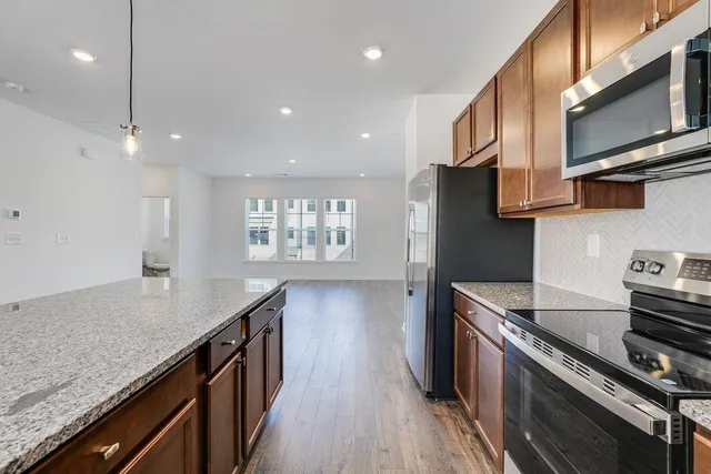 a kitchen with stainless steel appliances granite countertop a stove a sink and a refrigerator