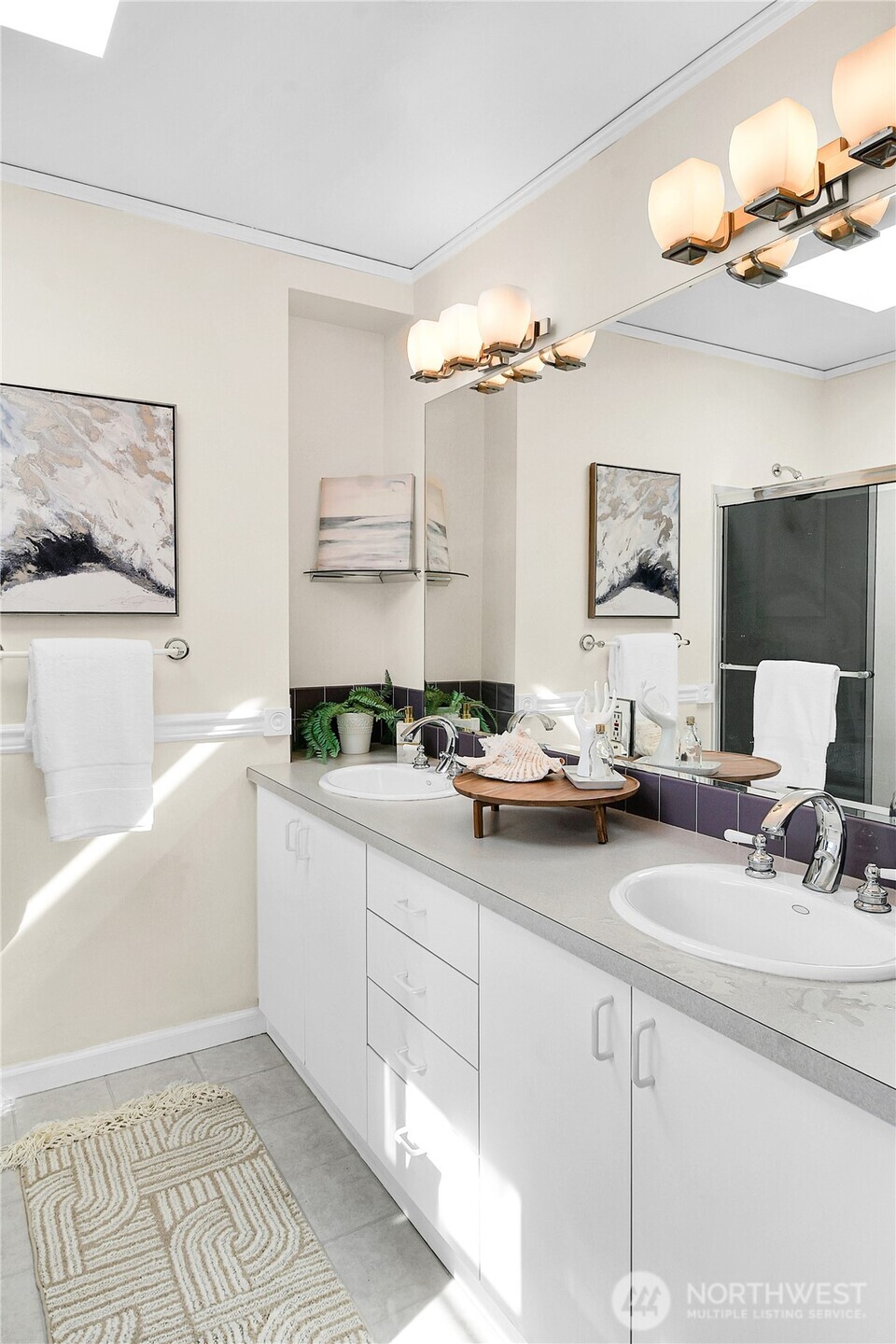 107 West Blaine Street Seattle, WA 98119 - Photo 15 of 22 a bathroom with a double vanity sink a mirror and a bathtub